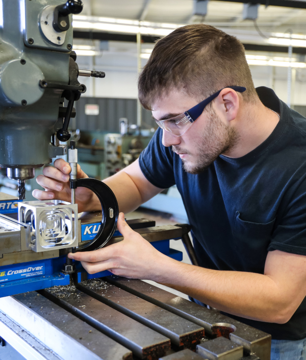 Northwest Shoals student working on manufacturing equipment.